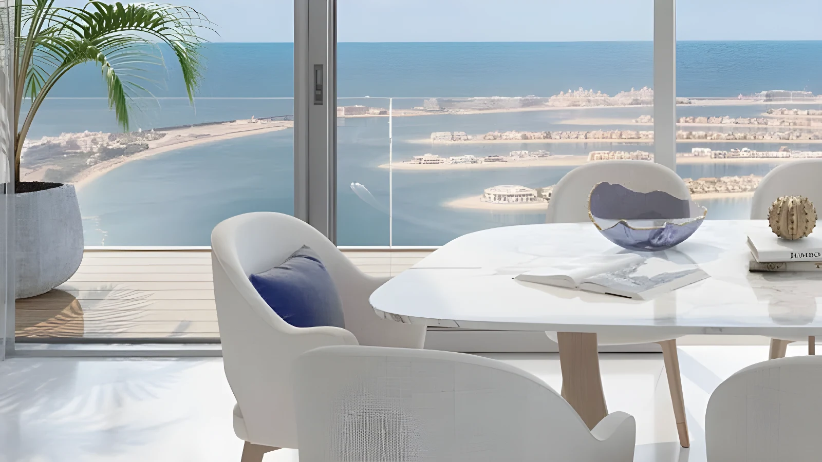 A dining space at Beach Isle with Palm Jumeirah through the glass